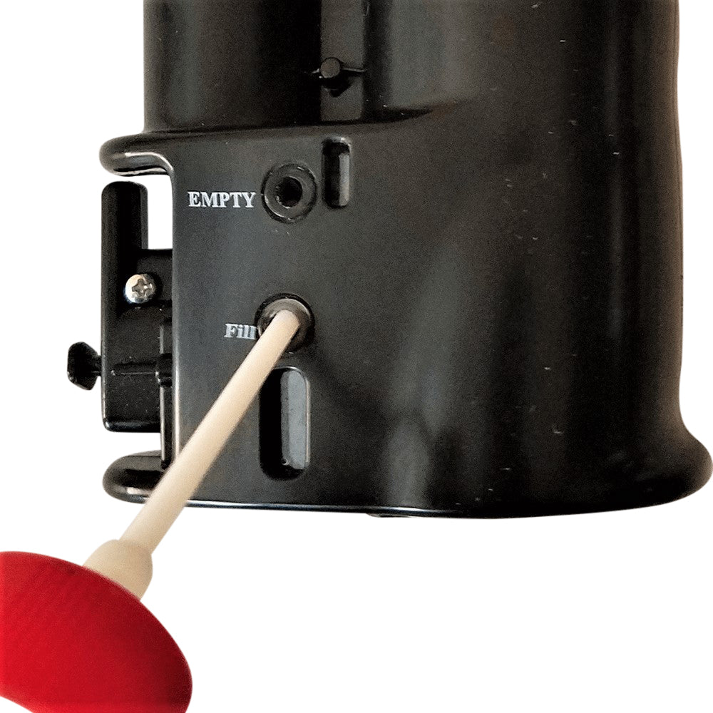 Close-up of a black cylindrical device with a small dial labeled EMPTY and FILL, being turned with a red-handled applicator on a white background.