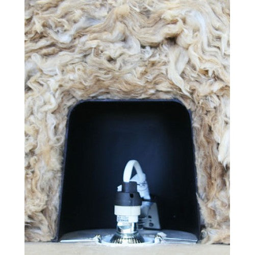 A close-up of a black fireplace insert or vent opening surrounded by beige and cream wool insulation material, with a metal and white damper or control component visible at the bottom center.